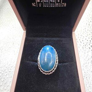 silver ring features a natural, cabochon-cut blue aquamarine gemstone set in a b